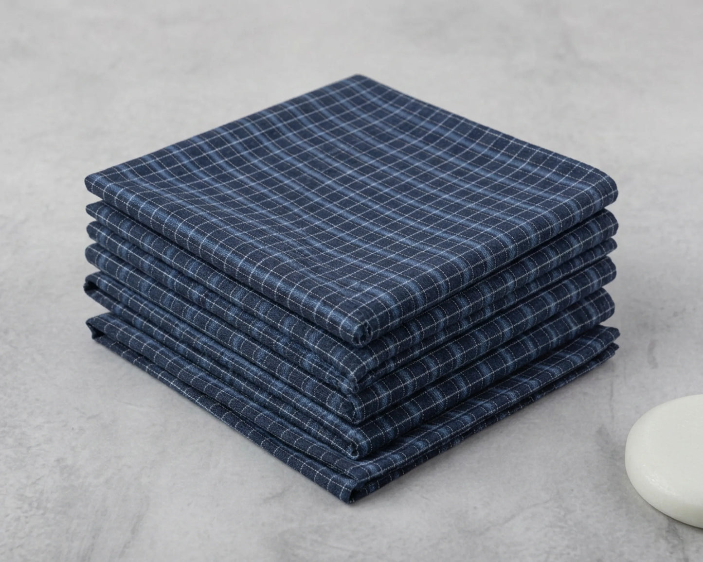 Stack of blue checkered hanky on a gray surface