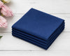 Stack of blue hanky on a white wooden surface with pink flowers.
