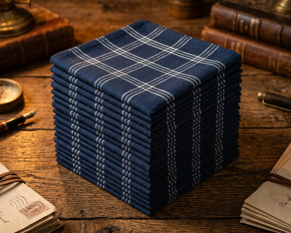 Stack of blue plaid hanky on a wooden surface with vintage books and stationery.