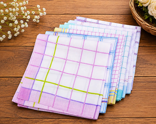Stack of colorful checkered hanky on a wooden surface with flowers and a basket in the background.