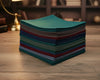 Stack of colorful folded handkerchief on a wooden surface with a blurred background