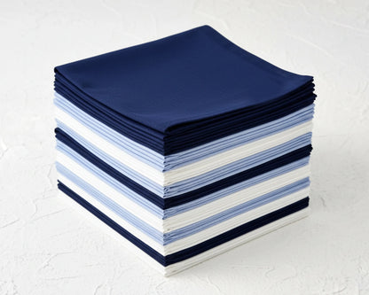 Stack of folded blue, white, and gray hanky on a textured white surface