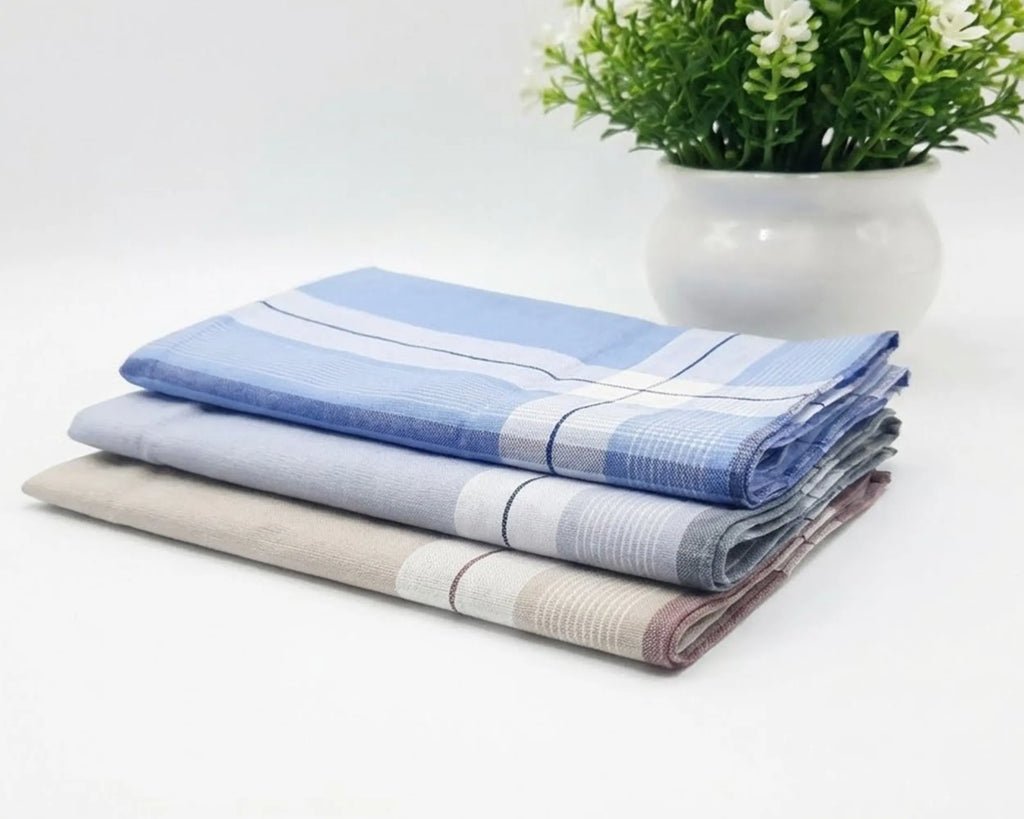 Stack of folded checkered HANKY on a white surface with a plant in the background