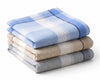 Stack of folded checkered hanky in blue, beige, and gray on a white background