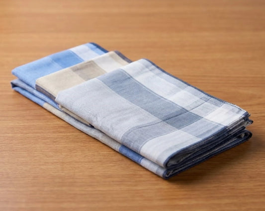 Stack of folded checkered towels on a wooden surface