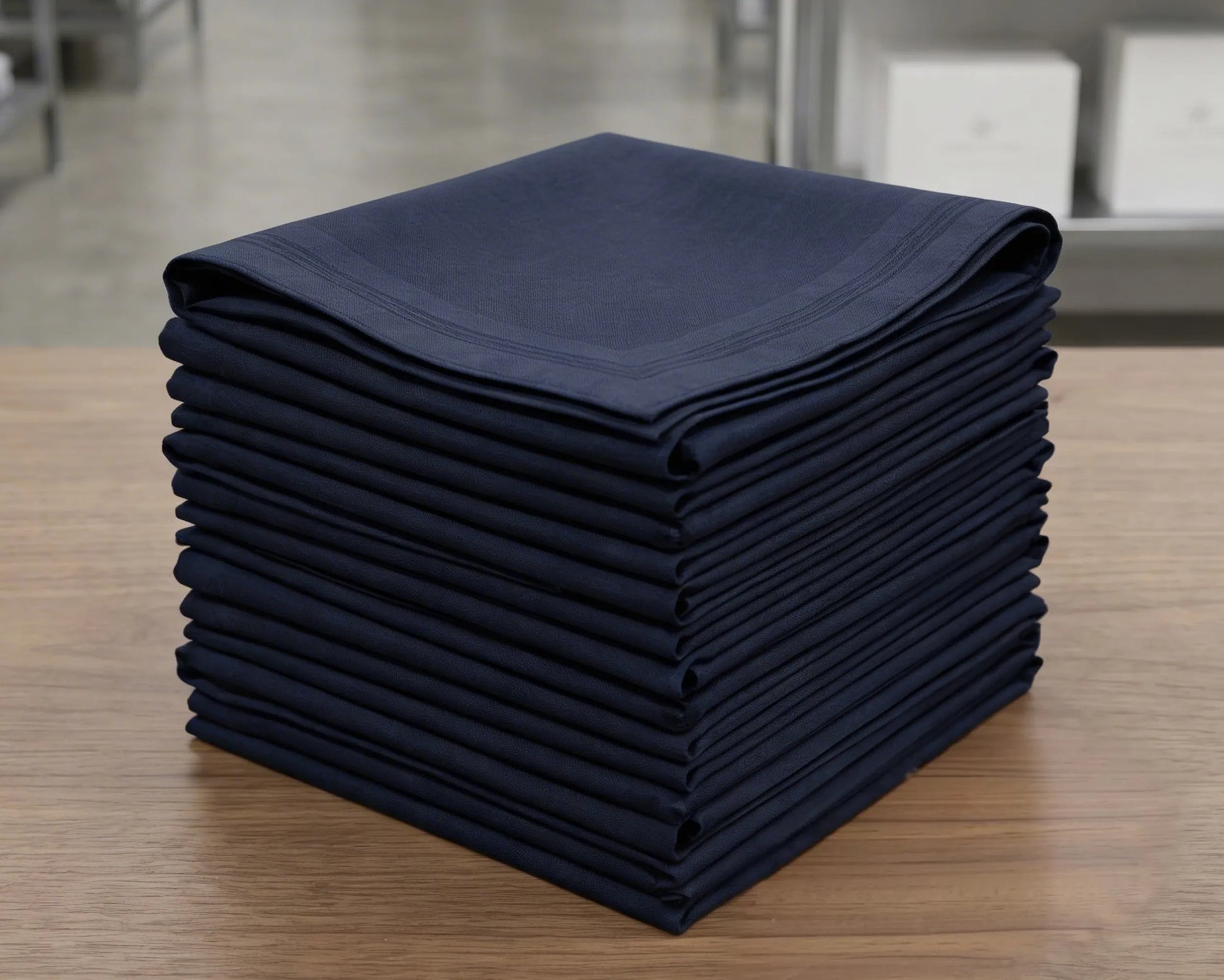 Stack of folded navy blue hanky on a wooden surface