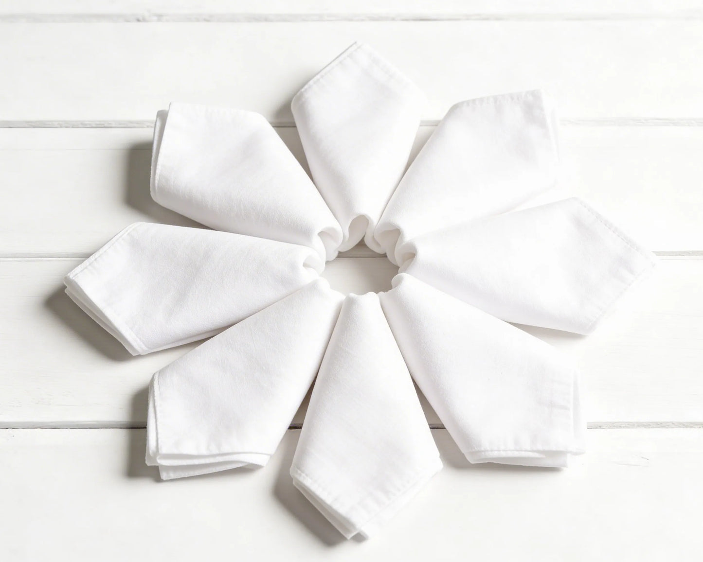 Stack of folded hanky in orange, green, and beige on a white background