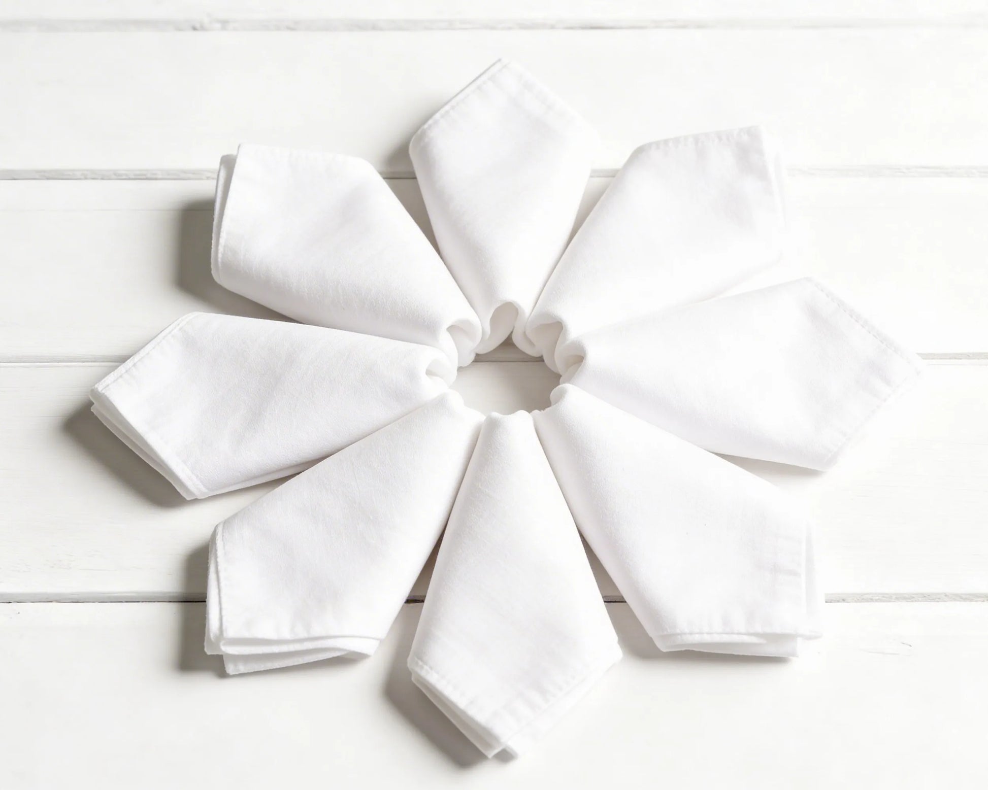 Stack of folded hanky in orange, green, and beige on a white background