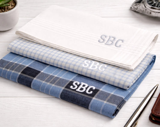 Stack of plaid fabric with 'SBC' monogram on a white surface