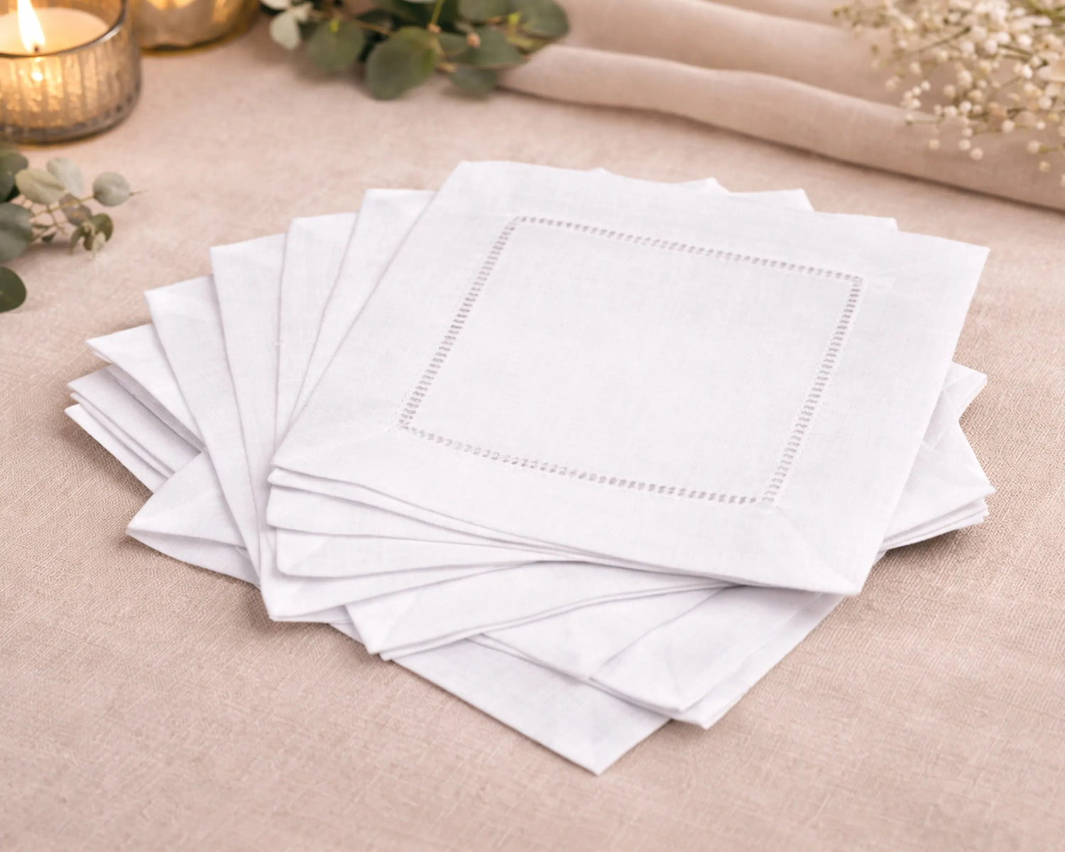 Stack of white napkins on a beige surface with decorative elements.