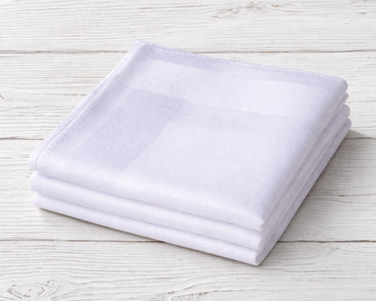 Stack of white folded towels on a light wooden surface