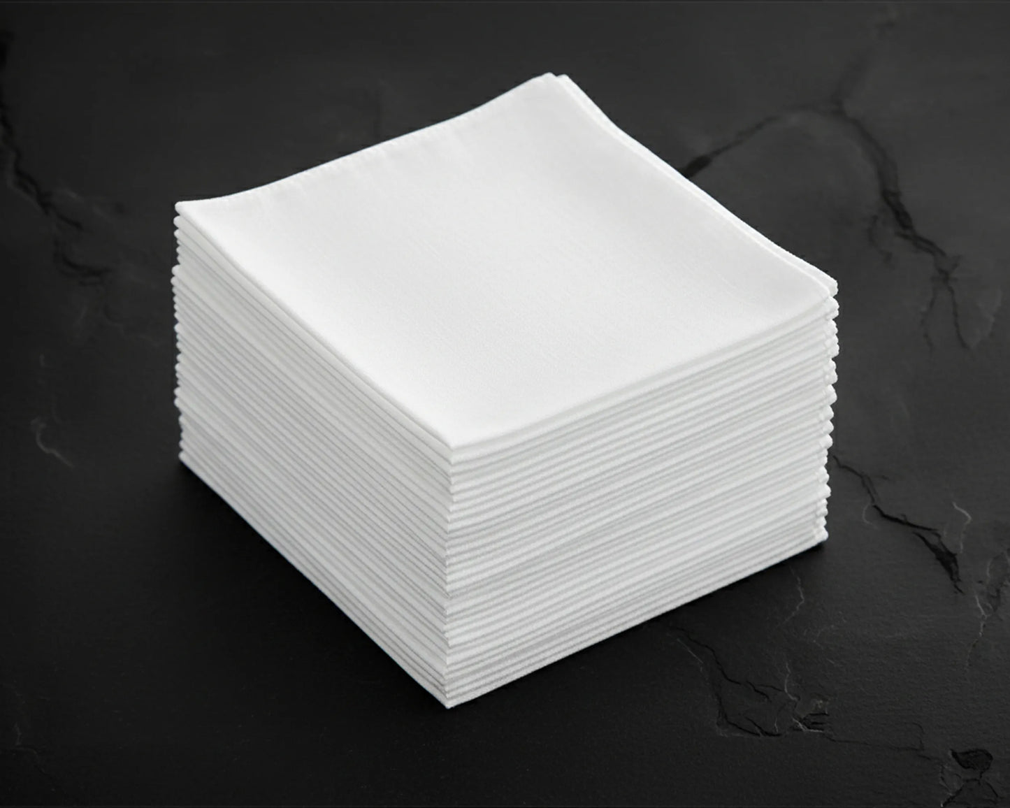 Stack of white hanky on a dark surface