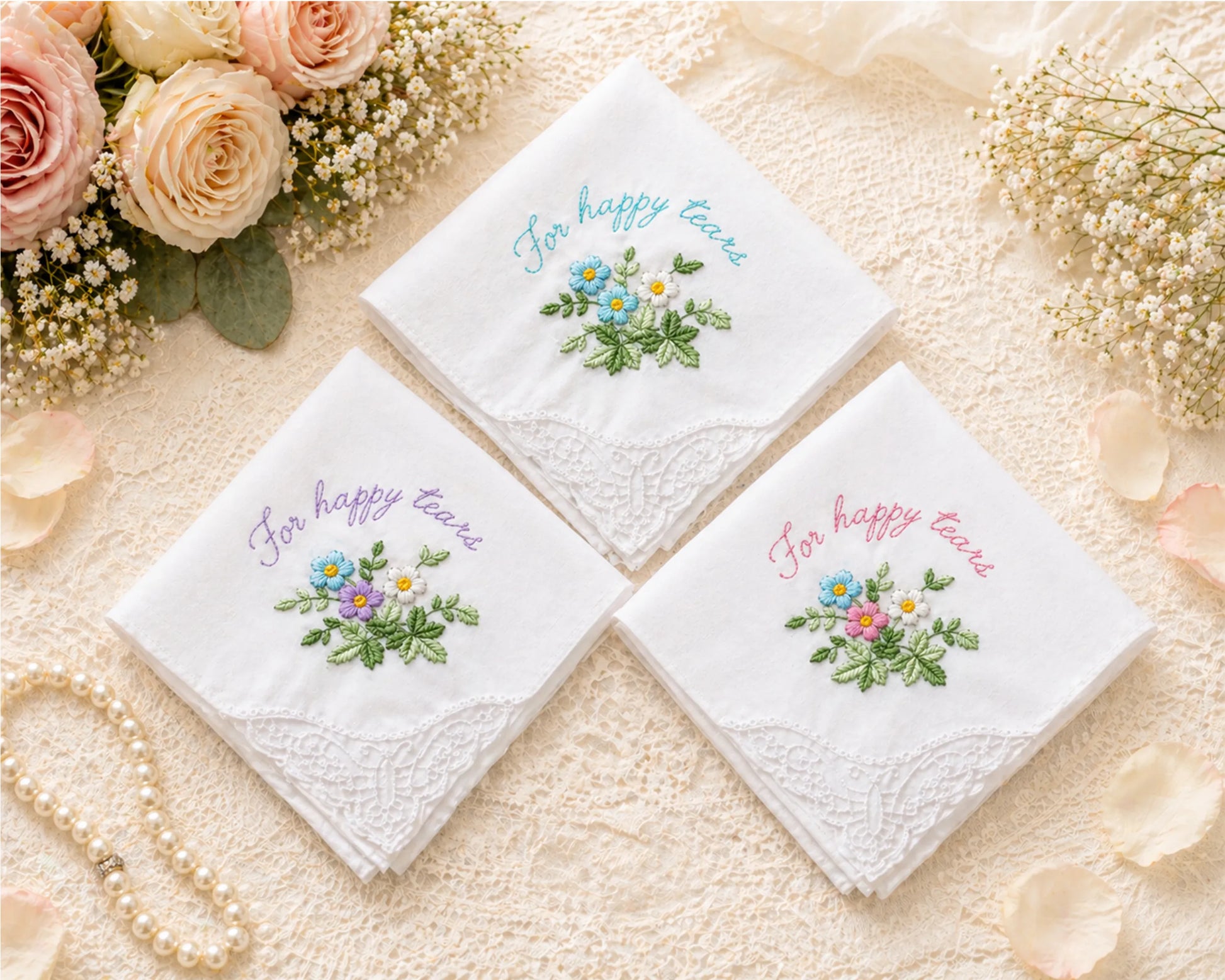 Three embroidered handkerchiefs with floral designs and text on a soft beige background.