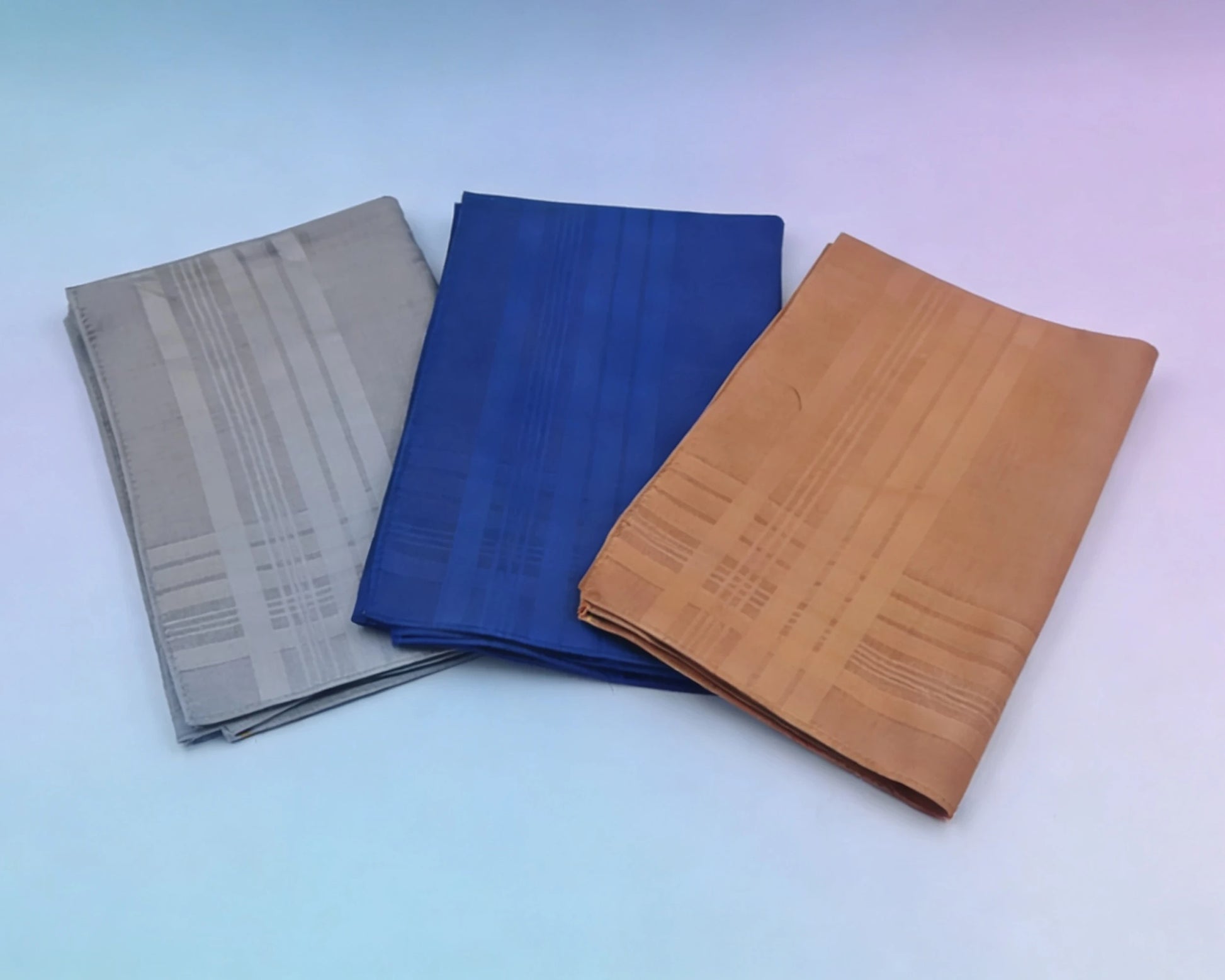 Three fabric samples in gray, blue, and brown on a gradient background