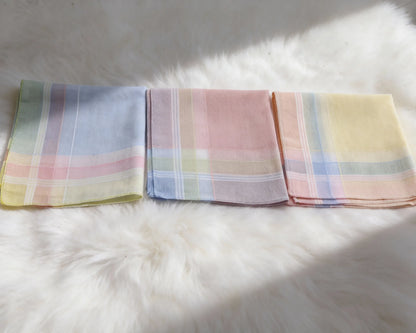 Three pastel colored plaid handkerchiefs on a white fur surface