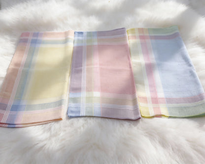 Three pastel plaid handkerchiefs on a white fur surface