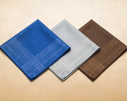 Three patterned hanky in blue, gray, and brown on a beige background