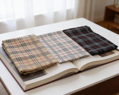Three plaid fabrics on an open book with a blurred background