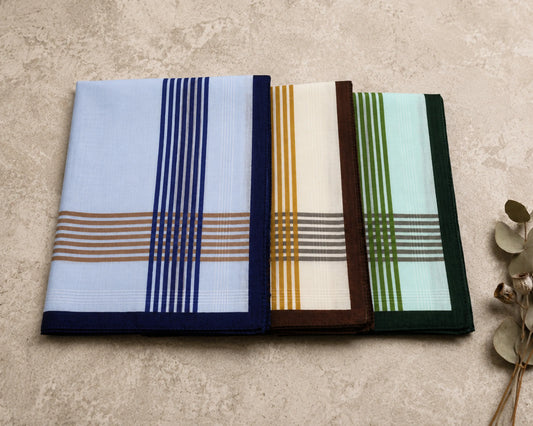 Three plaid handkerchiefs in different colors on a textured surface.