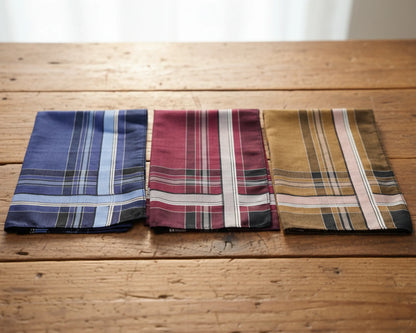 Three plaid pocket squares on a wooden surface