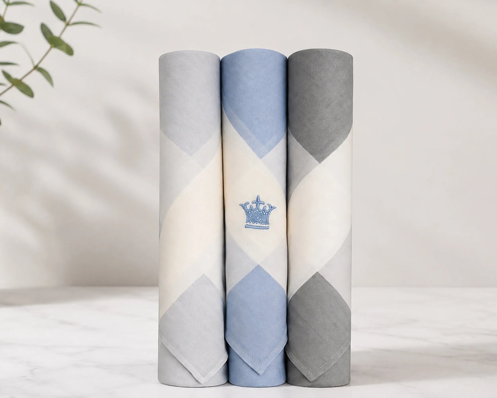 Three rolled-up men hanky with geometric patterns on a light background