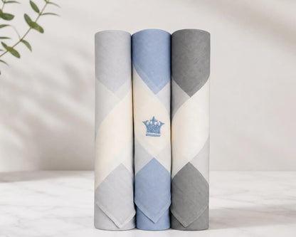 Three rolled-up men hanky with geometric patterns on a light background