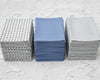 Three stacks of folded hanky on a textured white surface