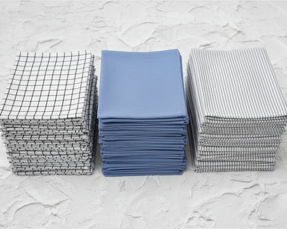 Three stacks of folded hanky on a textured white surface