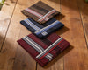 Three striped pocket squares on a wooden surface