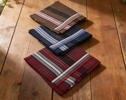 Three striped pocket squares on a wooden surface