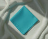 Turquoise napkin on a textured white surface