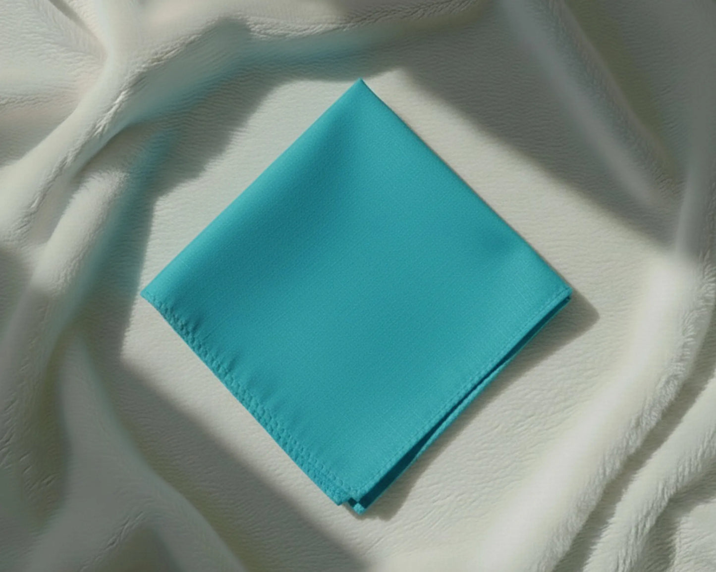 Turquoise napkin on a textured white surface