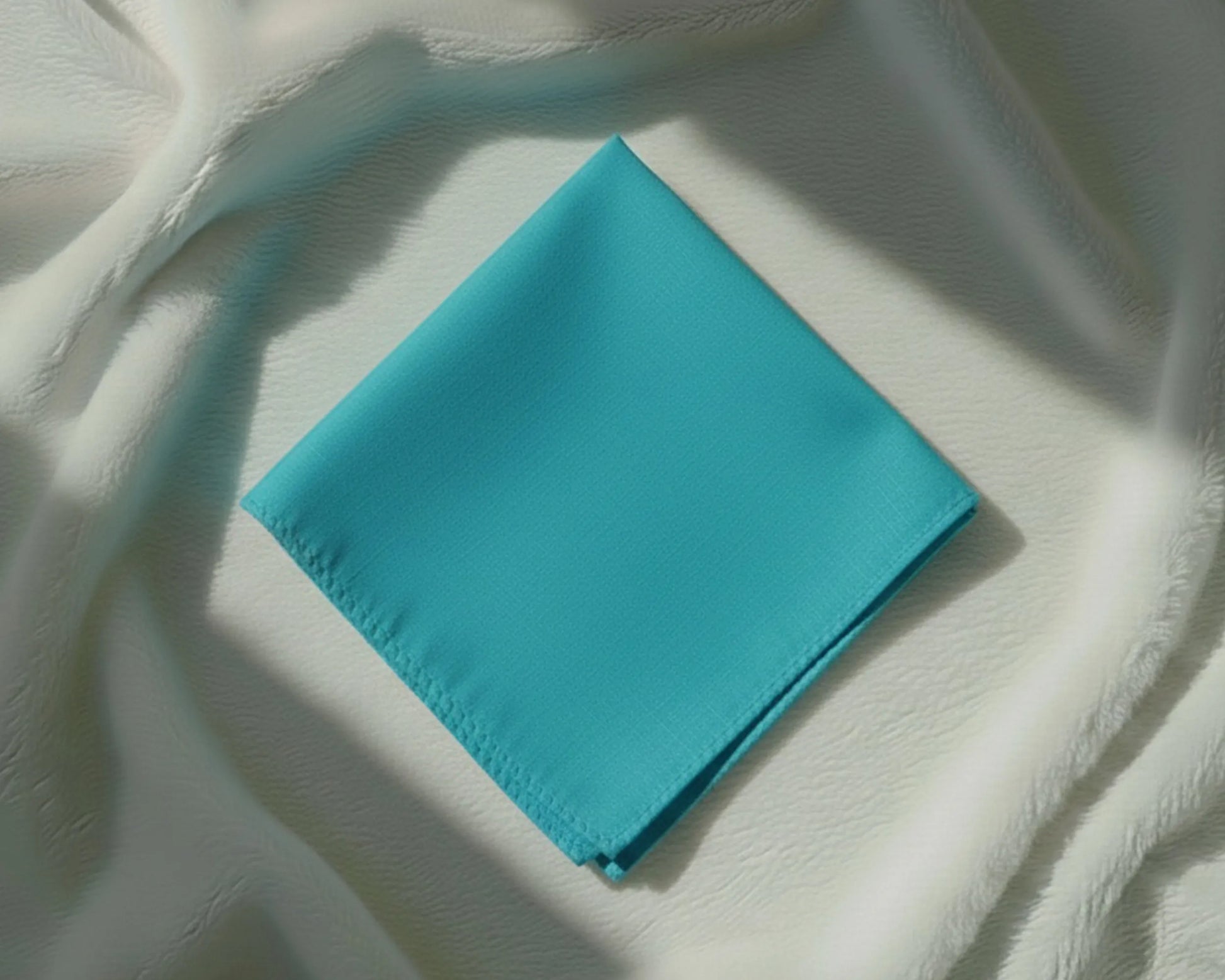 Turquoise napkin on a textured white surface
