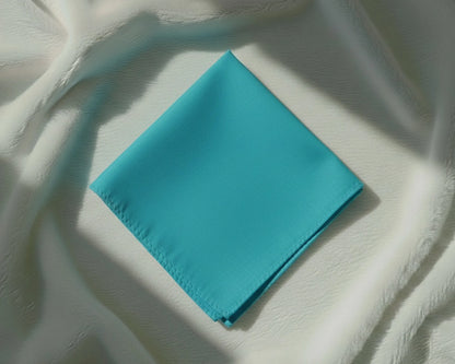 Turquoise napkin on a textured white surface