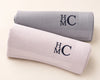 Two folded hanky with 'HMC' monogram on a light background