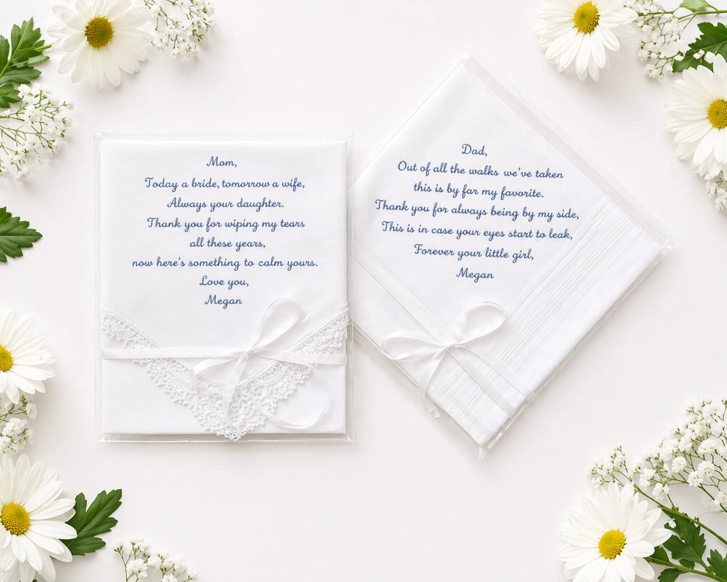 Two wedding handkerchief with heartfelt messages on a white surface surrounded by flowers