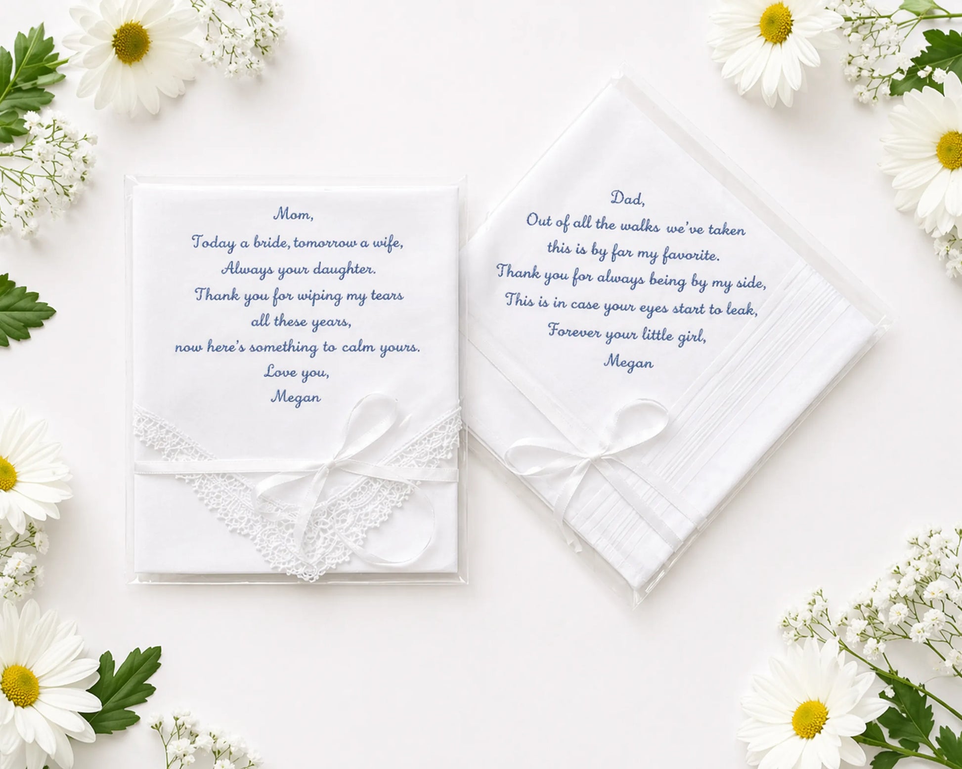 Two wedding handkerchief with heartfelt messages on a white surface surrounded by flowers