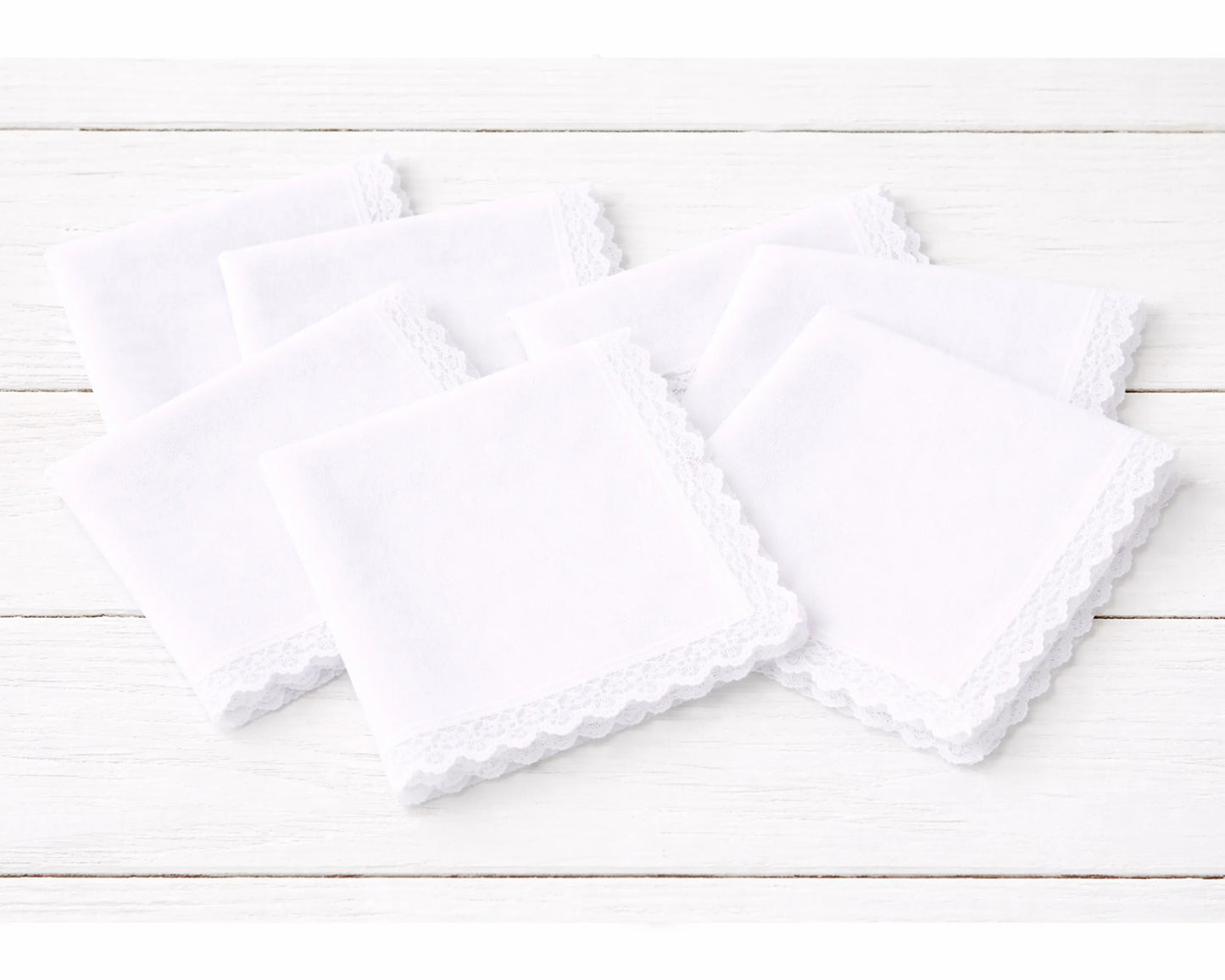 Two white  hanky on a light wooden surface