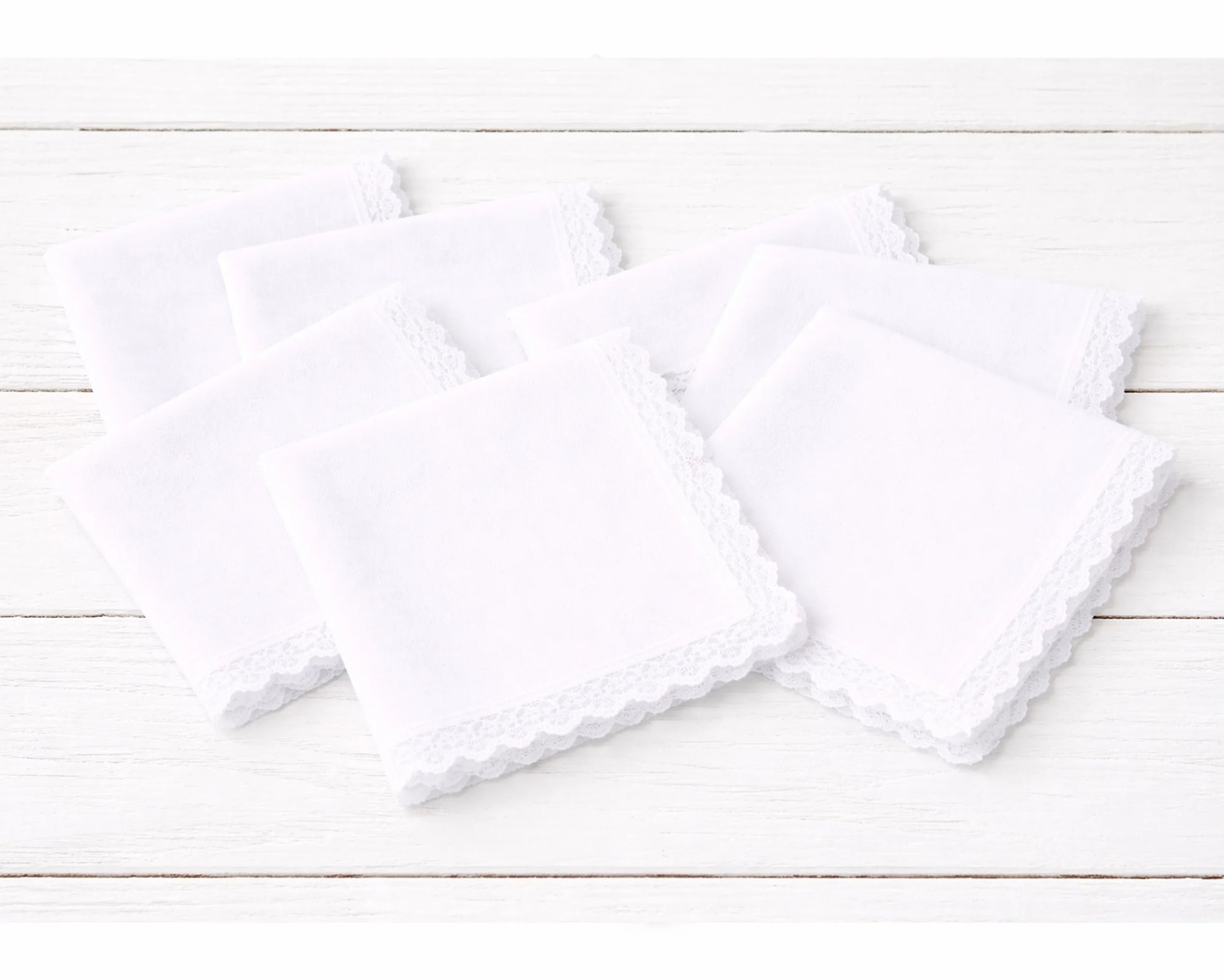 Two white  hanky on a light wooden surface