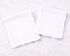 Two white rectangular hanky on a light gray textured surface