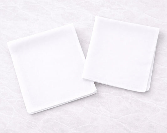 Two white rectangular hanky on a light gray textured surface