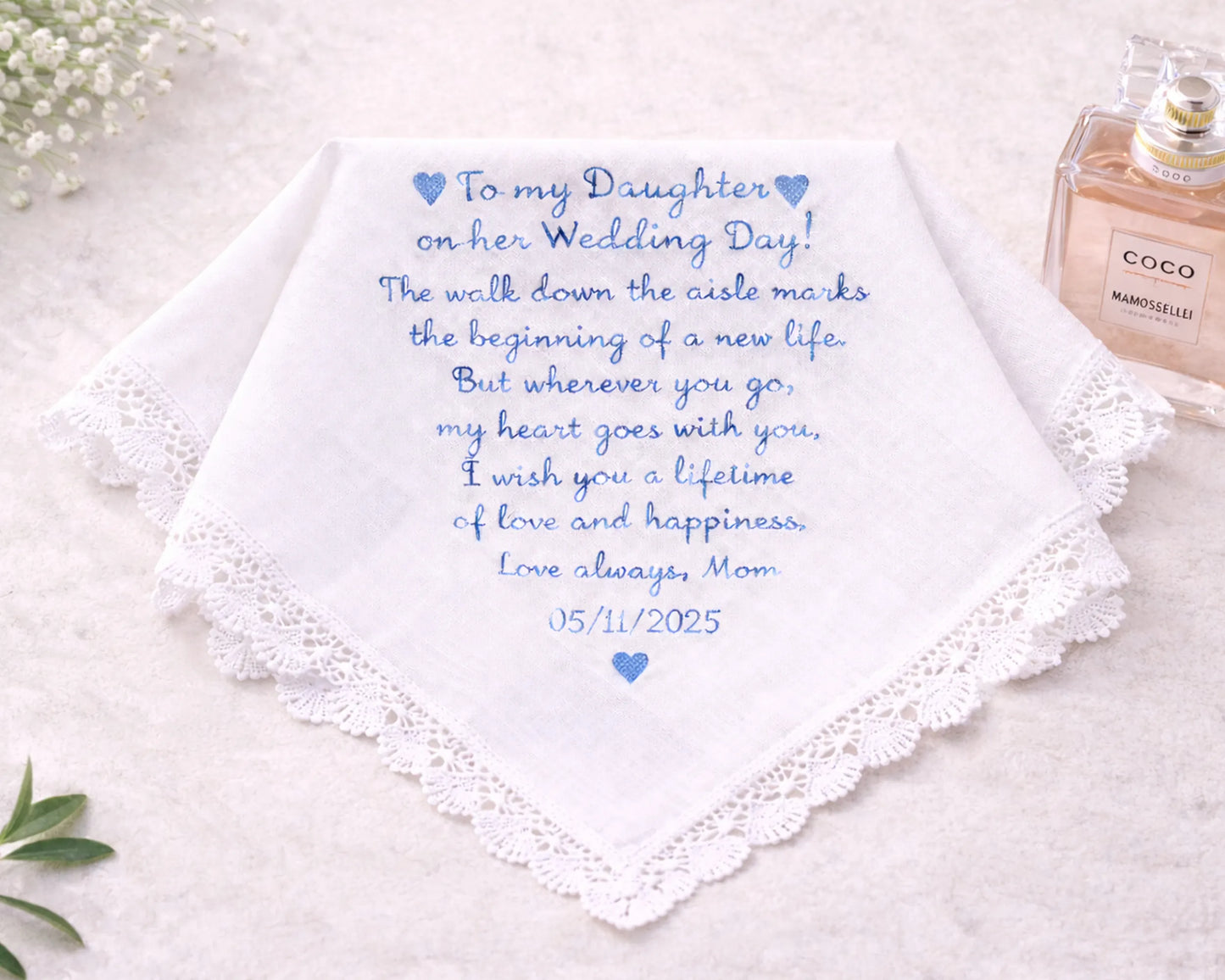 Wedding handkerchief with personalized message and date, placed on a light surface with a bottle of perfume.