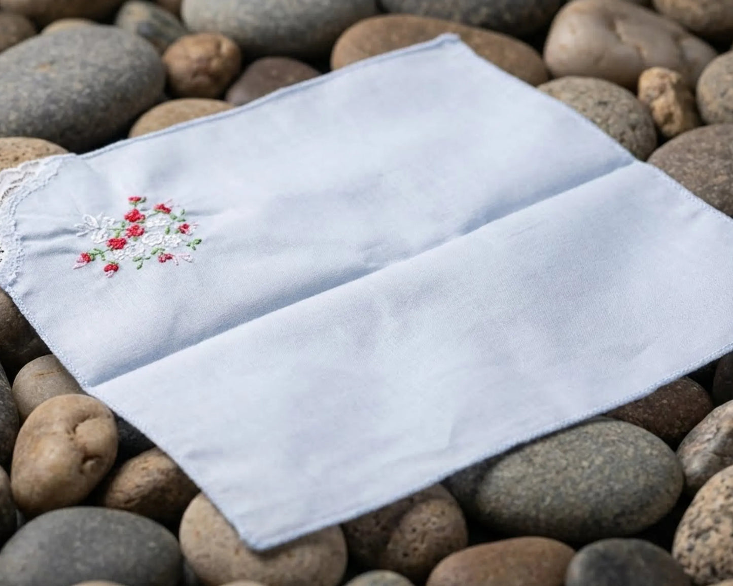 White embroidered handkerchief on a bed of stones