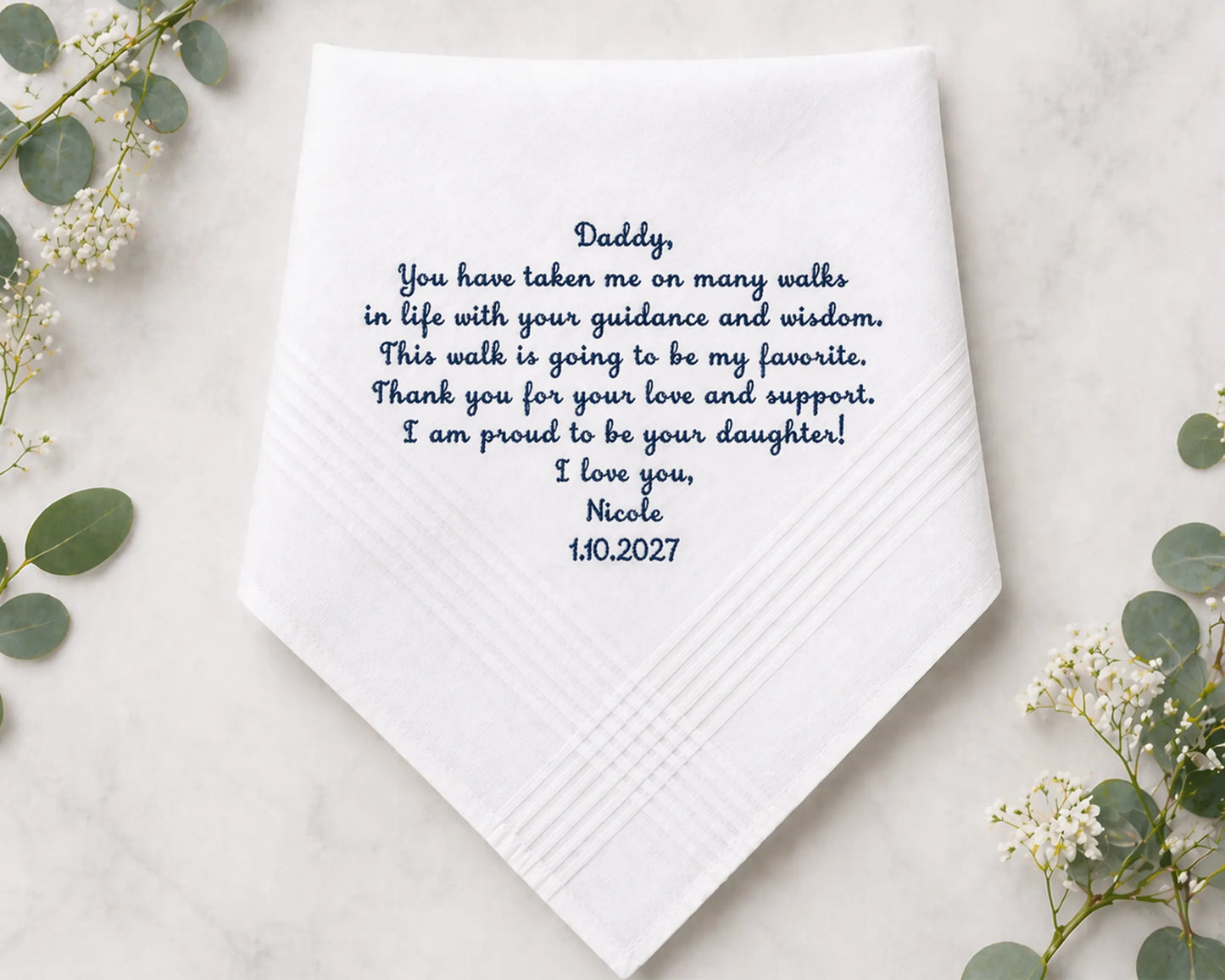 White handkerchief with personalized message on a light background with greenery