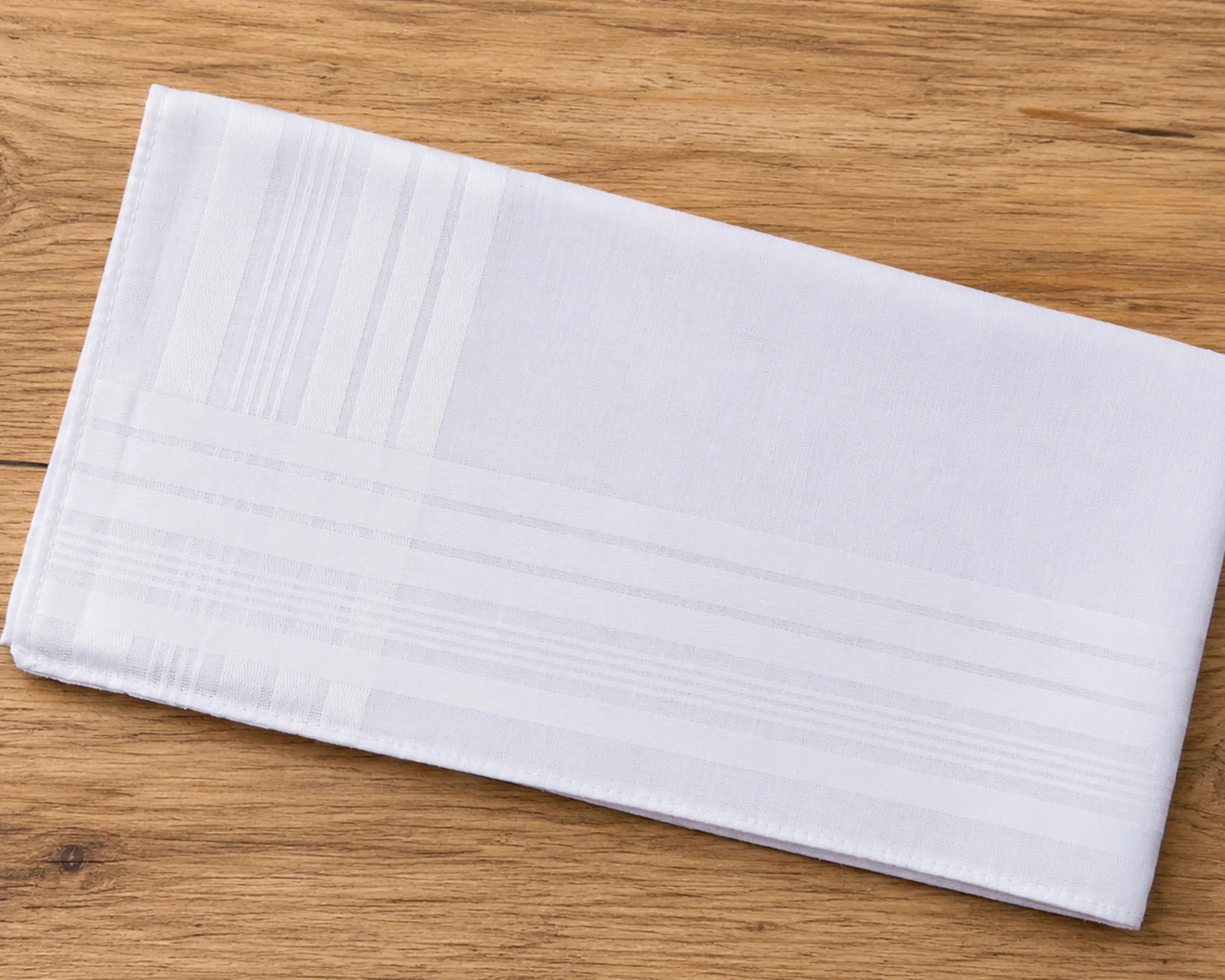 White folded hanky on a wooden surface