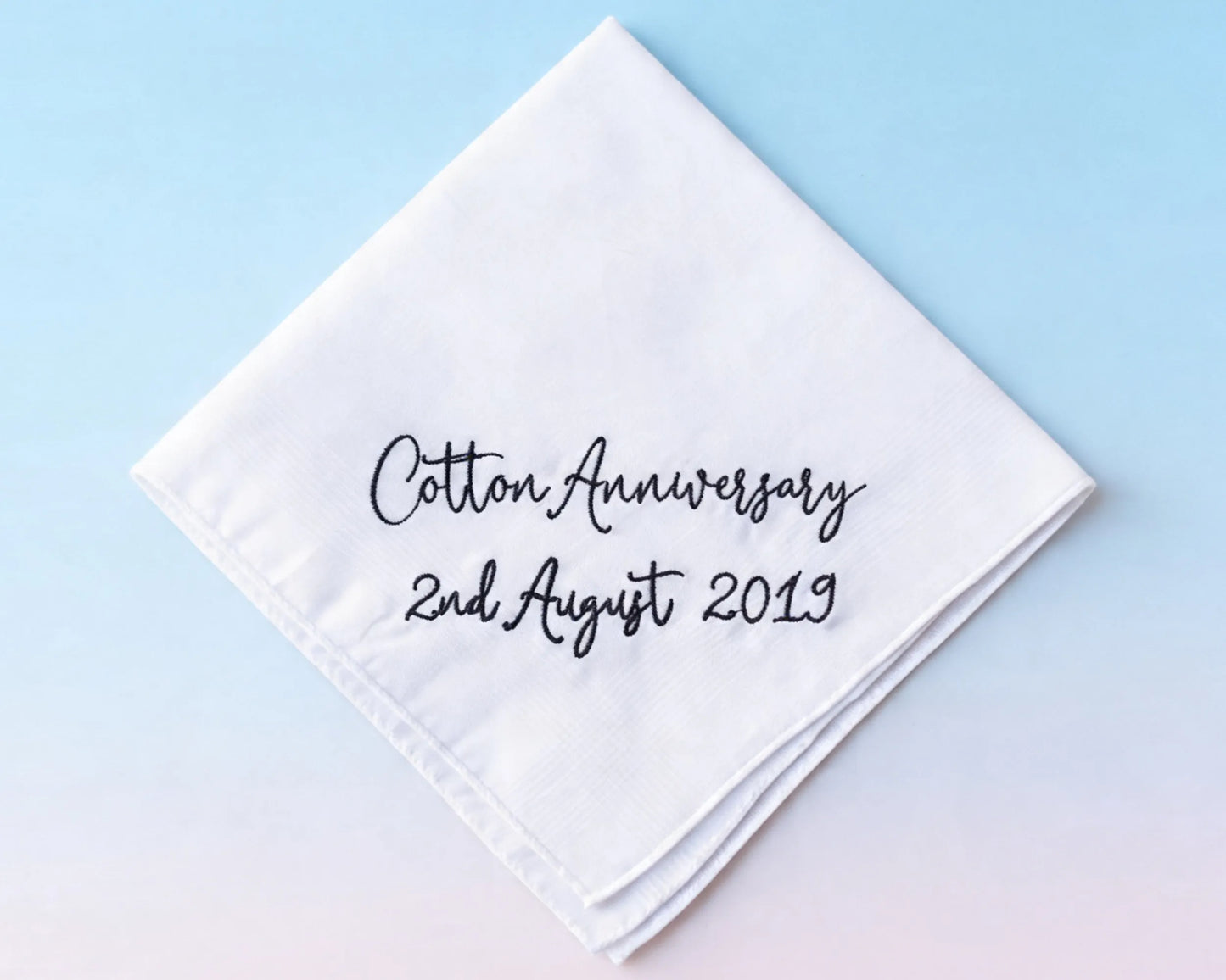 White handkerchief with 'Cotton Anniversary 2nd August 2019' text on a light blue background