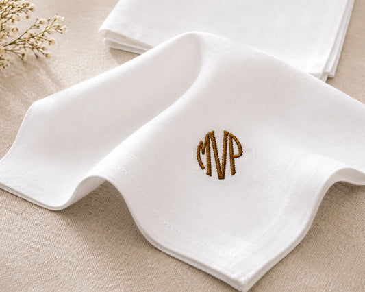 White handkerchief with 'MVP' embroidery on a beige surface