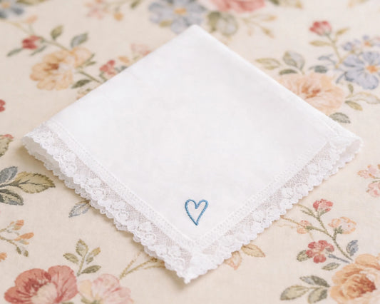 White handkerchief with a blue heart on a floral fabric background