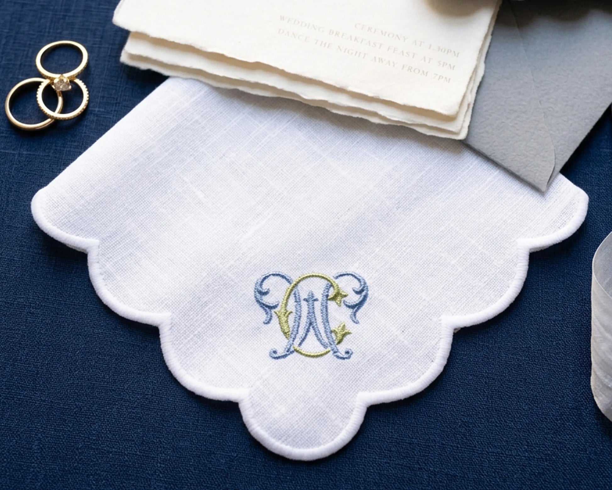 White handkerchief with a embroidered monogram on a blue surface