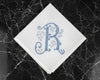 White handkerchief with blue monogram 'R' on a black marble surface
